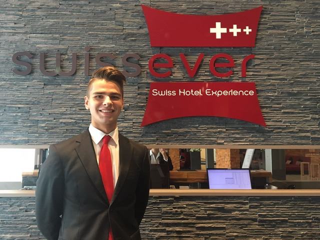 BHMS student working at a Swiss hotel reception desk during an industry placement